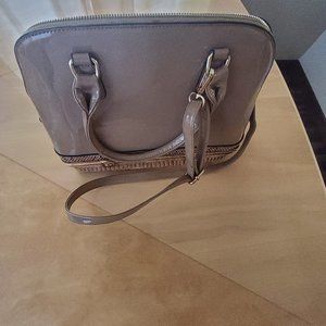 Two tone brown vinyl purse with compartment that opens at the bottom of the purs